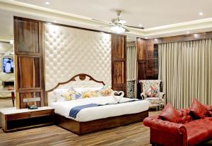 Hotel Vintage Zirakpur Chandigarh في بانتشكولا: غرفة نوم بسرير كبير واريكة حمراء