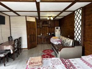 a room with two beds and a table and a kitchen at Sadyba u Anastasijky in Synevyr