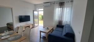 a living room with a blue couch and a table at Apartma Rian in Koper