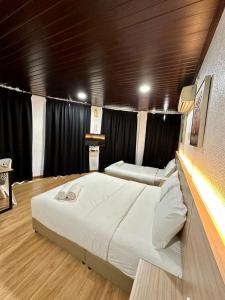 a large bed in a room with black curtains at Kangar Hotel Sdn Bhd in Kangar