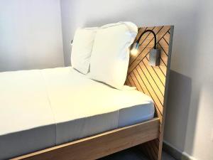 a bed with a pillow on top of it at 2 0 HÔTEL Ylang in Labattoir