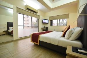 ムンバイにあるHotel Atlanticのベッド1台、薄型テレビが備わるホテルルームです。