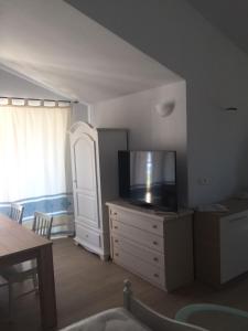 a living room with a flat screen tv on a dresser at Relax al Mare in Olbia