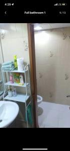 uma casa de banho com um lavatório, um WC e um chuveiro em Private Room in shared Apartment em Abu Dhabi