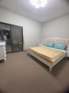 a bedroom with a bed with two blue pillows at Private Room in shared Apartment in Abu Dhabi