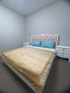 a bed with two blue pillows on it in a room at Private Room in shared Apartment in Abu Dhabi