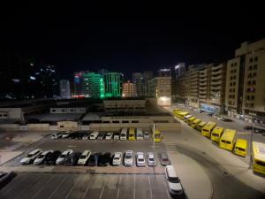 a parking lot with parked cars in a city at night at Private Room in shared Apartment in Abu Dhabi