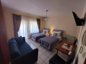 pokój hotelowy z 2 łóżkami i kanapą w obiekcie Eleni's Apartments Igoumenitsa - Γκαρσονιέρα 2ου ορόφου επιπλωμένη, εξοπλισμένη w mieście Igoumenitsa