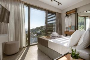 a bedroom with a bed and a large window at The View Hotel Sofas Coastal Retreat in Perdika
