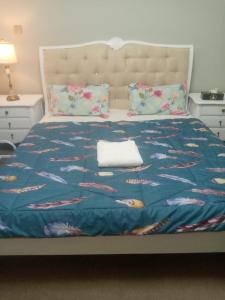 a bed with a blue blanket with fish on it at Private Room in shared Apartment in Abu Dhabi