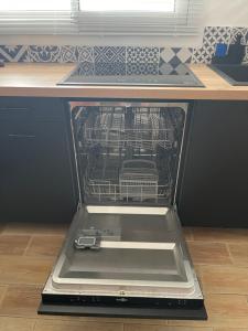 uma máquina de lavar louça com a porta aberta numa cozinha em Le CAP6 em Cassis