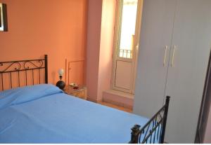 Un dormitorio con una cama azul y una ventana en Casa Fortunato, en Naso