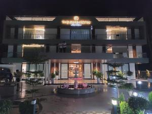 a building with a fountain in front of it at night at Green Icon Hotels & Resorts in Kandogal