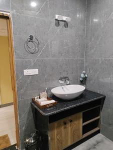 a bathroom with a white sink on a counter at Green Icon Hotels & Resorts in Kandogal