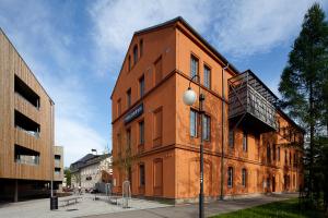 - un bâtiment orange avec un balcon sur le côté dans l'établissement Hostel Lípa - Továrna, à Krásná Lípa