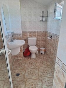 a bathroom with a toilet and a sink at Ivanovi Guest House in Primorsko