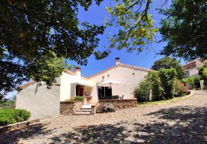 - une vue sur l'extérieur d'une maison blanche dans l'établissement La Casa Del Pou classée 3 étoiles proche Céret et Thuir Terrain 800m2 Parking privé, à Llauro