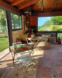 un patio con mesa, sillas y ventanas en BnB Bagno di Bosco, en Gubbio