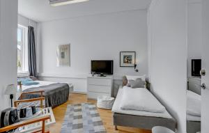 a white room with two beds and a flat screen tv at Villa Gertrud in Kolding