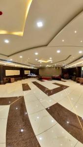 um grande átrio com um grande piso de azulejo branco em Hotel Govindam Elite em Juhi Bari