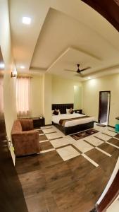 a bedroom with a bed and a couch at Hotel Govindam Elite in Juhi Bari