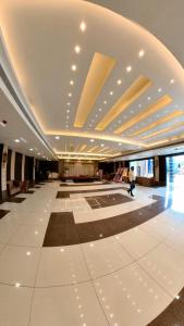 a large building with a lobby with a person walking in it at Hotel Govindam Elite in Juhi Bari