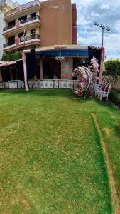 a building with chairs and flowers in a yard at Hotel Govindam Elite in Juhi Bari