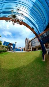 uma grande estrutura azul num campo com um edifício em Hotel Govindam Elite em Juhi Bari