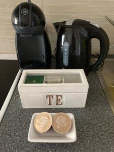 a tea pot and two coins on a counter with a coffee maker at Mehri in Uppsala