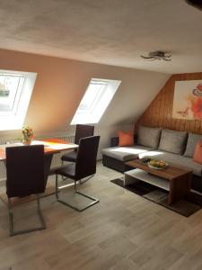 sala de estar con sofá y mesa en Ferienwohnung-Ritscher-in-Lichtenhain-2, en Lichtenhain