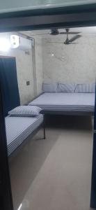 two empty beds in a room with a wall at PREMIER MANSION in Chennai