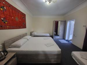 1 dormitorio con 2 camas y lámpara de araña en Bobo Haydar Guest House, en Bukhara
