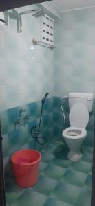 a bathroom with a toilet and a red bucket at PREMIER MANSION in Chennai +36 photos
