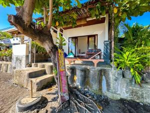 a house with a tree in front of it at Kumpul Beach in Amed