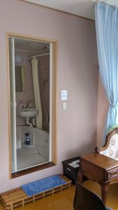 a bathroom with a mirror and a sink and a table at Pension Alba - Vacation STAY 70925v in Tateyama
