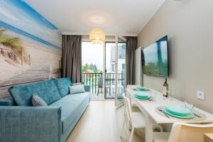 sala de estar con sofá azul y mesa blanca en Apartamenty Baltic Island en Gdansk