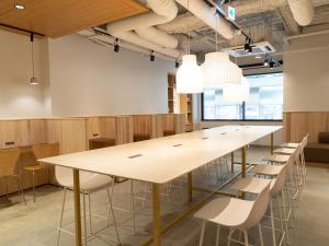 uma grande sala de conferências com uma grande mesa e cadeiras em Hotel Plus Hostel SAPPORO em Sapporo