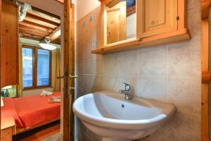 uma casa de banho com um lavatório e uma cama em 42- Casetta Benetollo Vacanza in Toscana - CASA PRIVATA em Castel del Piano