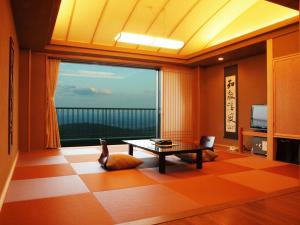 a living room with a table and a large window at Kounkaku in Nihommatsu