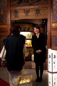 twee vrouwen die voor een winkel staan bij Kounkaku in Nihommatsu