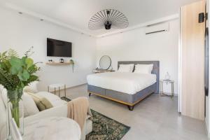 a bedroom with a bed and a couch and a tv at New beautiful studio, private terrace-Hvar town in Hvar
