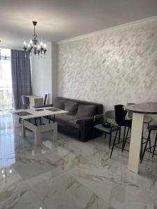 Apartment in centre of Yerevan في يريفان: غرفة معيشة مع أريكة وطاولة وكراسي