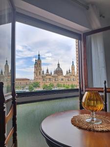 - une table dans une chambre avec vue sur un bâtiment dans l'établissement Apartamento Con Vistas Al Pilar con Aparcamiento privado, à Saragosse