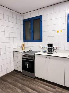 a kitchen with white appliances and blue cabinets at رايدن in Abha