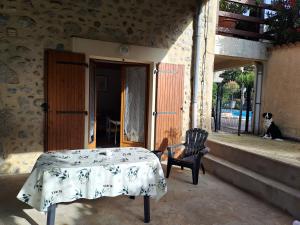 a table and a chair on the porch of a house at Gîte 4 "OLIA" aux Magnolias in Aubenas