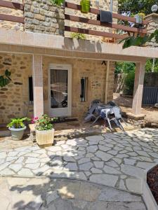 a patio with a table and chairs and a building at Gîte 2 "Le Tilia " aux magnolias 3 étoiles in Aubenas