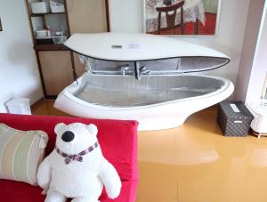 a white teddy bear sitting on a red couch at Pension Alba - Vacation STAY 70965v in Tateyama