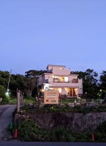 una gran casa blanca con un cartel delante en Pension Alba - Vacation STAY 70965v en Tateyama