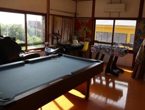 una mesa de billar en una habitación con ventanas en Pension Alba - Vacation STAY 70965v en Tateyama