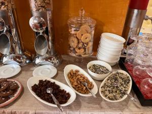 einen Tisch mit Schalen verschiedener Arten von Lebensmitteln in der Unterkunft Hotel Teco in Mailand